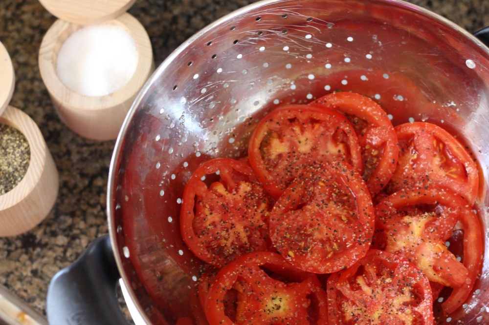 Sliced tomatoes drained in a colander